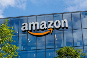 Amazon logo mounted on the glass exterior of a modern corporate office building.